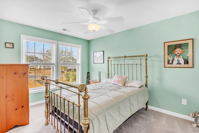 carpeted bedroom featuring a ceiling fan, visible vents, and baseboards