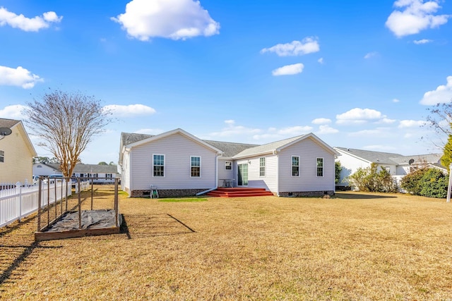 rear view of house with a yard and fence