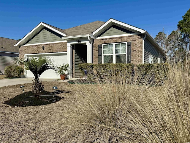 ranch-style house featuring an attached garage, driveway, and brick siding