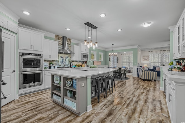 1118 Prescott Cir, Myrtle Beach, SC 29577 - kitchen with wall chimney exhaust hood, stainless steel appliances, ornamental molding, open floor plan, and a chandelier