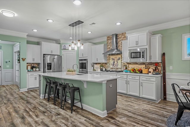1118 Prescott Cir, Myrtle Beach, SC 29577 - kitchen with stainless steel appliances, wall chimney exhaust hood, ornamental molding, white cabinets, and a wainscoted wall