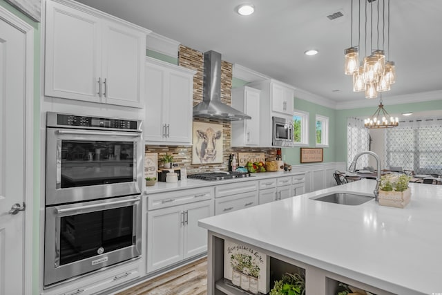 1118 Prescott Cir, Myrtle Beach, SC 29577 - kitchen featuring appliances with stainless steel finishes, wall chimney range hood, a sink, a chandelier, and light countertops