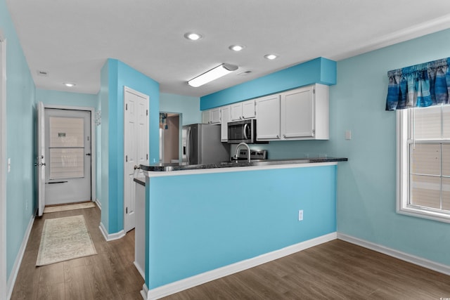 561 White River Dr Unit 11-D, Myrtle Beach, SC 29579 - kitchen featuring appliances with stainless steel finishes, dark wood-type flooring, white cabinetry, a peninsula, and baseboards