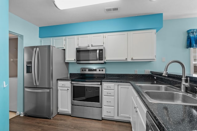 561 White River Dr Unit 11-D, Myrtle Beach, SC 29579 - kitchen featuring appliances with stainless steel finishes, a sink, white cabinets, dark wood finished floors, and dark stone counters