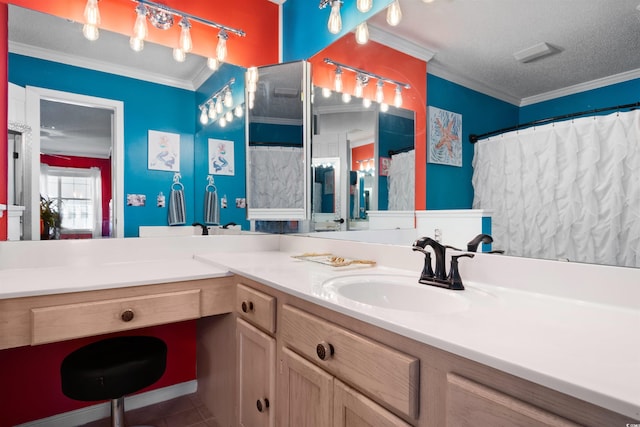 bathroom featuring a textured ceiling, ornamental molding, and vanity