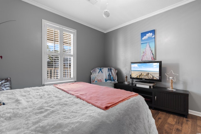 bedroom with crown molding, baseboards, and wood finished floors