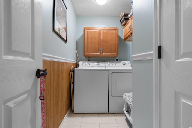 laundry room featuring light tile patterned floors, cabinet space, independent washer and dryer, and a textured ceiling