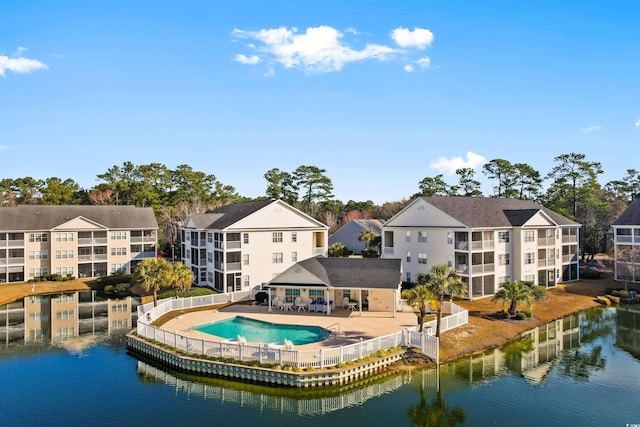 rear view of house featuring a water view, a community pool, and a fenced backyard