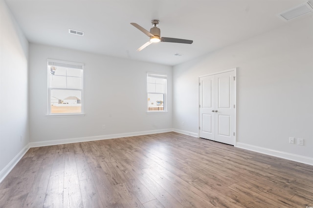 spare room featuring visible vents, plenty of natural light, and wood finished floors