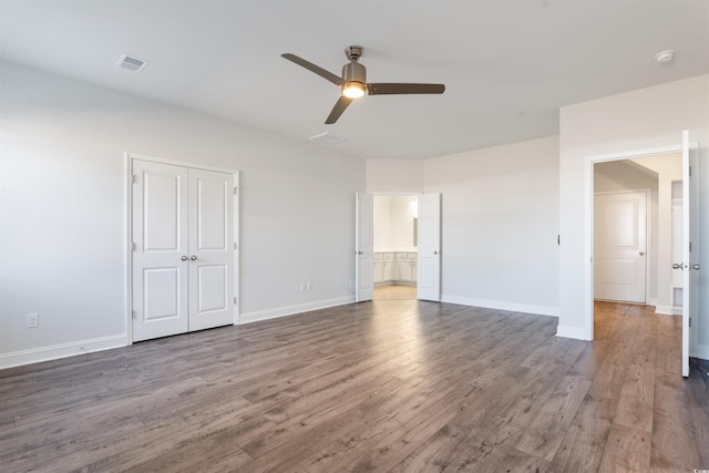 unfurnished bedroom with ceiling fan, wood finished floors, visible vents, and baseboards