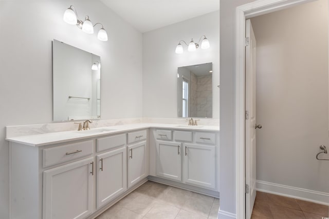 full bathroom featuring tile patterned flooring, a sink, baseboards, and double vanity