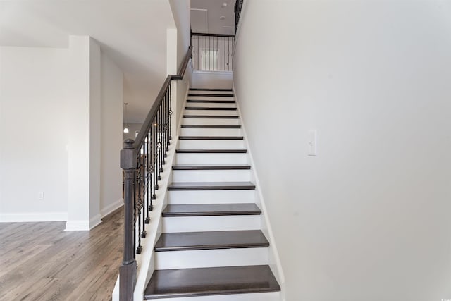 stairway featuring wood finished floors and baseboards