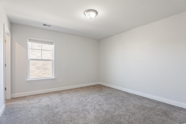 carpeted empty room with visible vents and baseboards