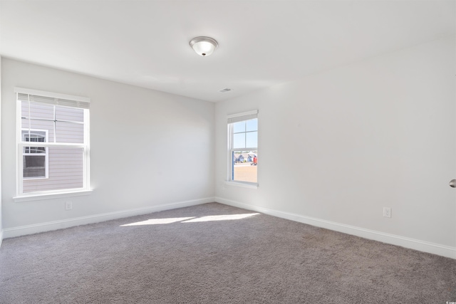 empty room featuring carpet floors and baseboards