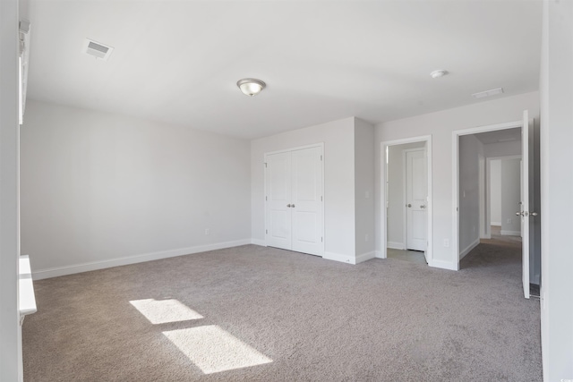 unfurnished bedroom with carpet floors, baseboards, visible vents, and a closet