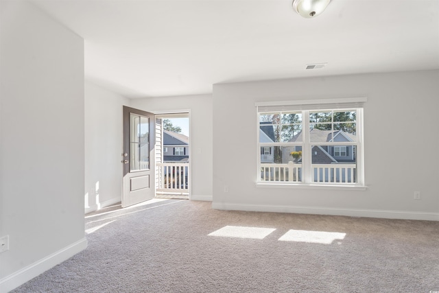 carpeted spare room featuring baseboards and visible vents