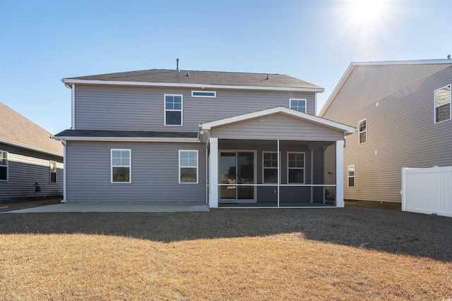 rear view of property with a yard, a patio area, and a sunroom