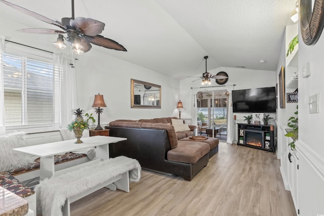 218 Landing Rd Unit G, North Myrtle Beach, SC 29582 - living room with a ceiling fan, vaulted ceiling, light wood-type flooring, and a glass covered fireplace