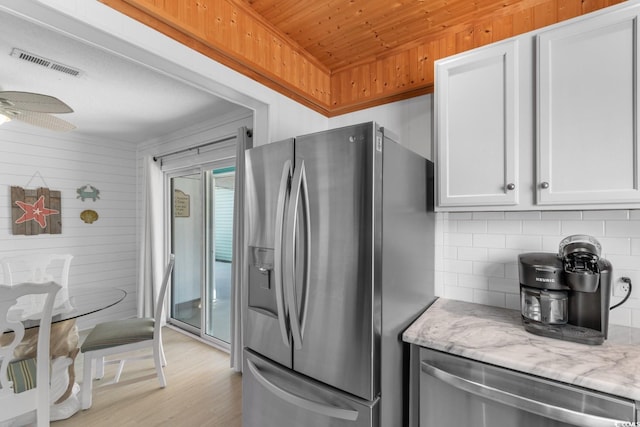 kitchen with light wood finished floors, visible vents, backsplash, appliances with stainless steel finishes, and white cabinets