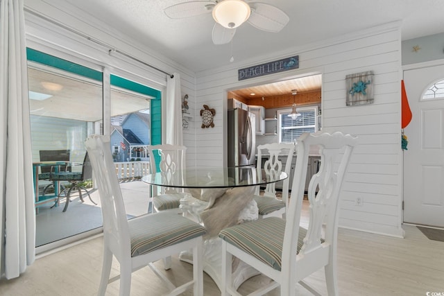 dining area featuring ceiling fan, light wood-type flooring, plenty of natural light, and a sunroom