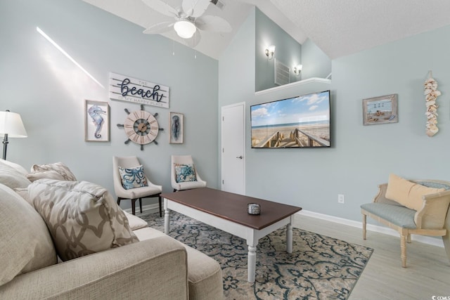 living room featuring a textured ceiling, high vaulted ceiling, wood finished floors, a ceiling fan, and baseboards