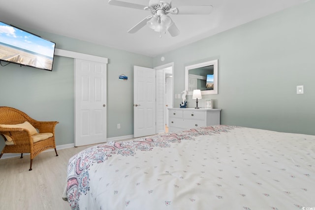 bedroom featuring baseboards, ceiling fan, a closet, and light wood-style floors