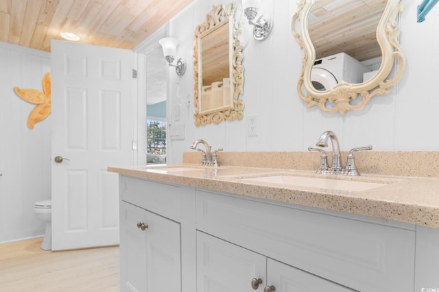 bathroom with double vanity, wooden ceiling, a sink, and toilet