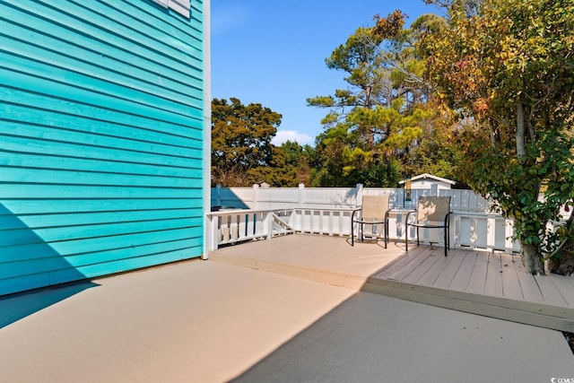 wooden terrace featuring a patio area and fence