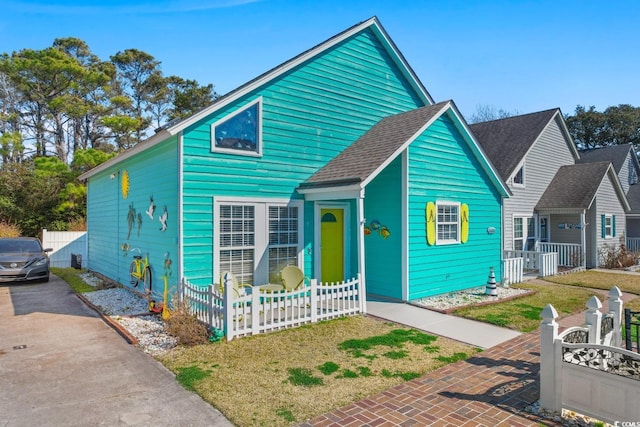 bungalow-style home featuring a shingled roof and fence