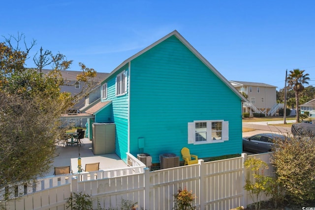 view of home's exterior with a fenced backyard, central AC, and a patio