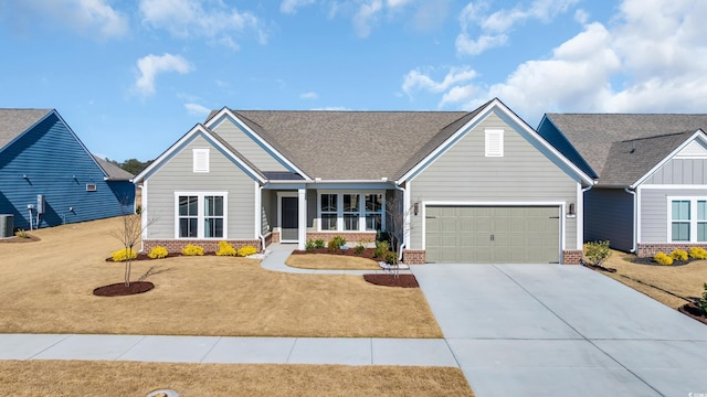 view of front of property with a front lawn, concrete driveway, brick siding, and an attached garage