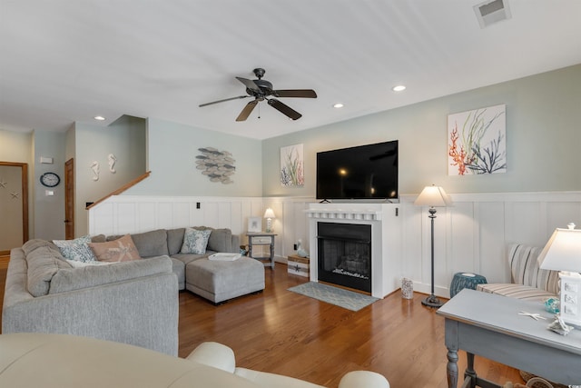 living area with recessed lighting, a fireplace with flush hearth, wood finished floors, visible vents, and a ceiling fan