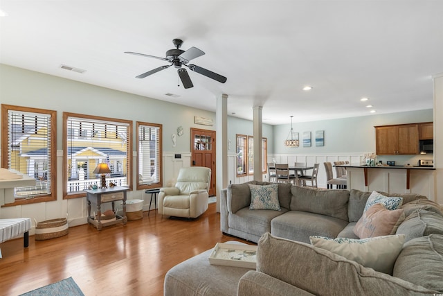 living area with ceiling fan, recessed lighting, wood finished floors, visible vents, and wainscoting