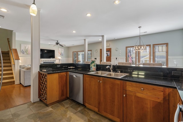 kitchen featuring a wainscoted wall, a sink, open floor plan, brown cabinets, and dishwasher