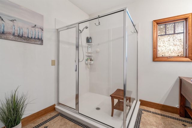 full bathroom featuring a shower stall, baseboards, and tile patterned floors