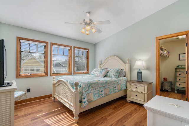 bedroom with light wood-type flooring, baseboards, and a ceiling fan