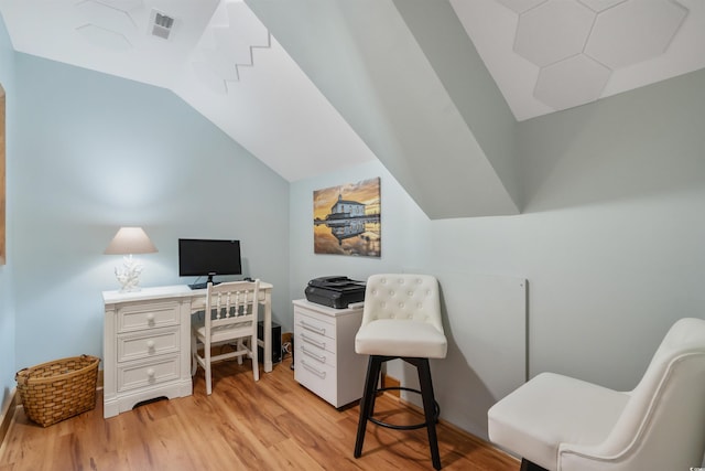 office space featuring lofted ceiling, light wood finished floors, and visible vents