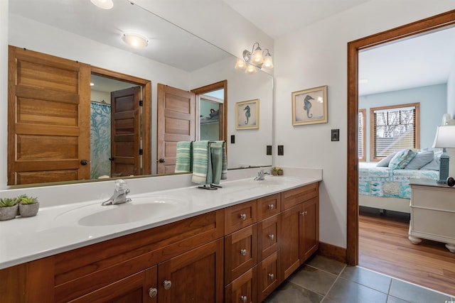 bathroom featuring connected bathroom, tile patterned flooring, a sink, and double vanity