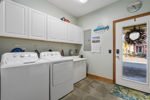 clothes washing area with baseboards, washer and clothes dryer, cabinet space, and electric panel