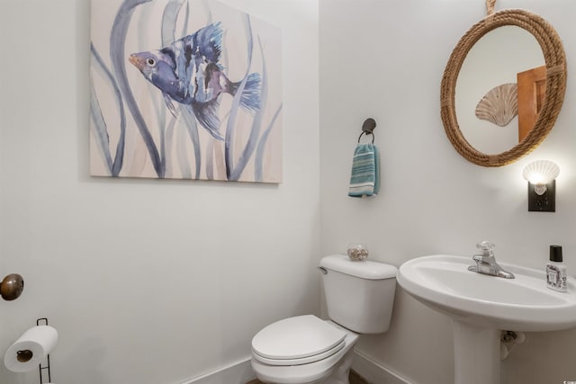 bathroom with baseboards and toilet