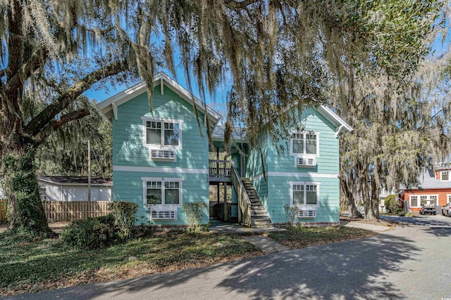 view of front of property featuring stairway and fence