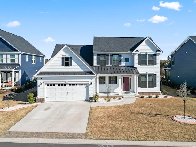 view of front facade with a garage, driveway, a standing seam roof, and a front yard