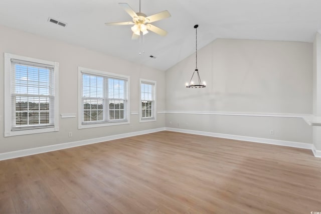 unfurnished dining area with ceiling fan with notable chandelier, light wood-type flooring, visible vents, and baseboards