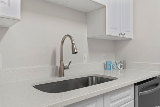 kitchen with dishwasher, light countertops, a sink, and white cabinets