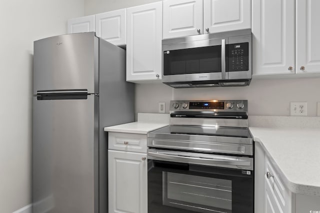 kitchen featuring white cabinets, stainless steel appliances, and light countertops