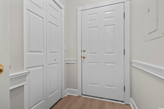 doorway featuring light wood-type flooring and baseboards