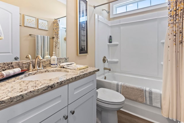 full bathroom featuring wood finished floors, shower / tub combo, vanity, and toilet