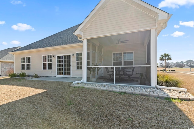 back of house with a shingled roof, a patio, a sunroom, ceiling fan, and a yard