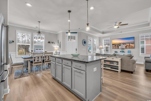 kitchen with gray cabinets, a center island, freestanding refrigerator, and light wood-style floors