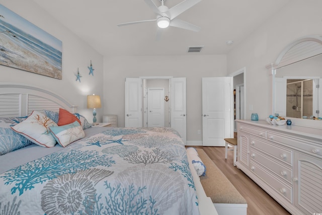 bedroom featuring visible vents, ensuite bath, ceiling fan, and light wood finished floors